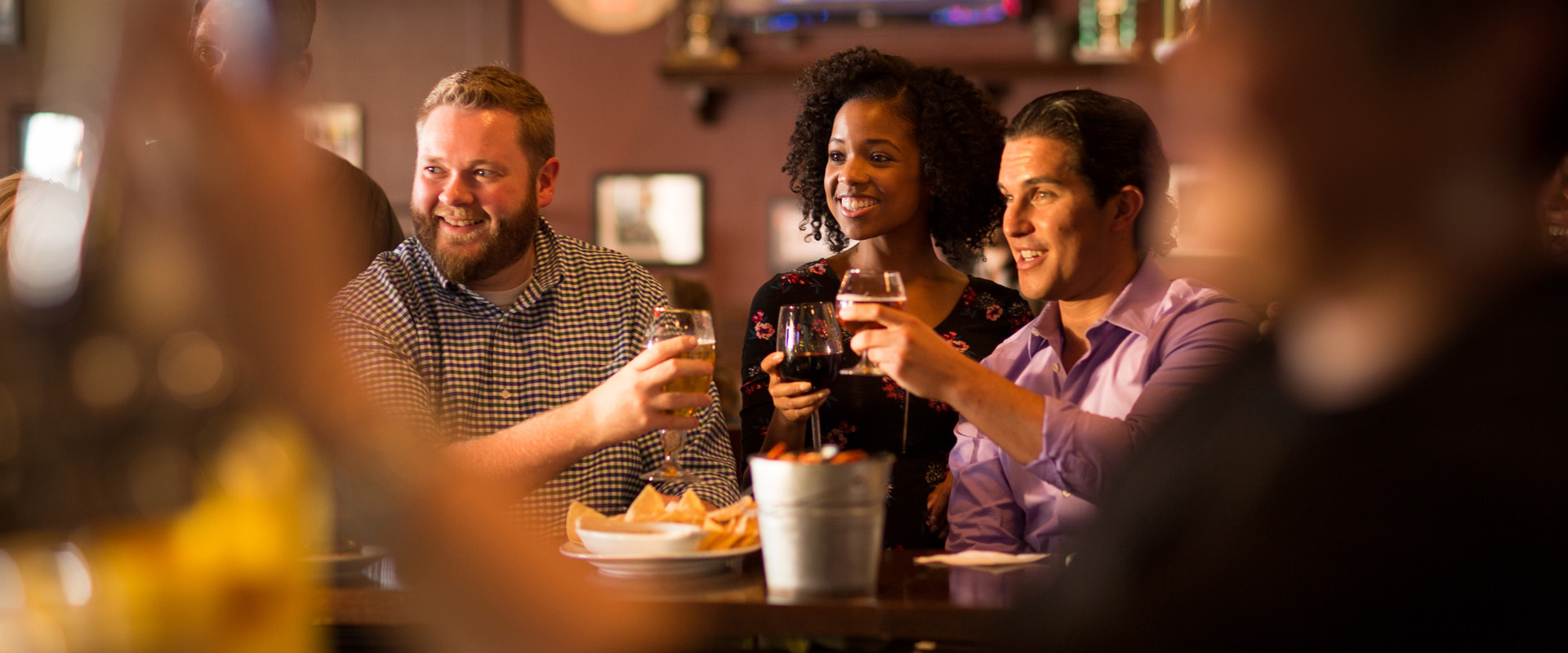 Friends enjoying happy hour and toasting with beer at the Rusty Bucket