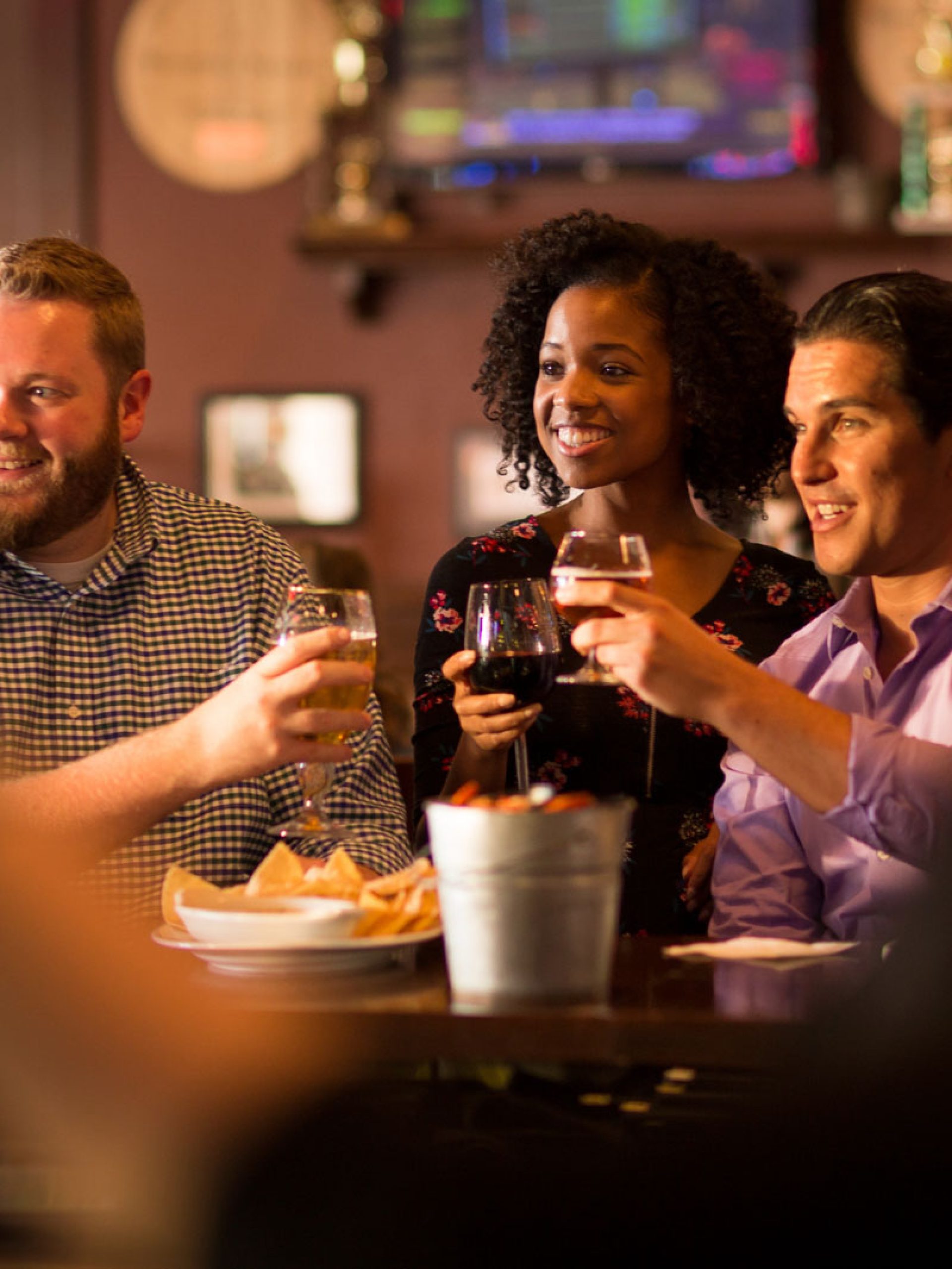 Friends enjoying happy hour and toasting with beer at the Rusty Bucket